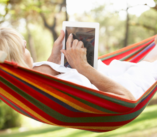 Woman lying on Hammock using iPad